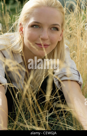 Young woman relaxing in tall grass, portrait Stock Photo