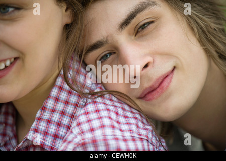 Young man resting head on girlfriend's shoulder, cropped portrait