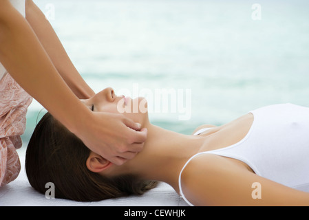 Young woman receiving face massage, side view Stock Photo