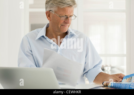 Senior man working on laptop computer at home Stock Photo