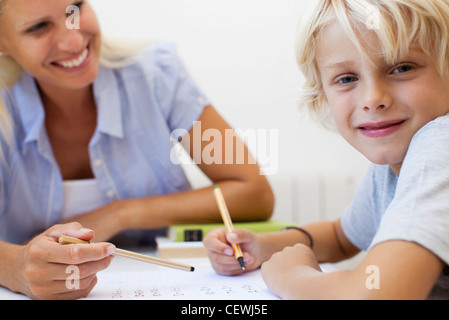 Boy doing homework, smiling at camera Stock Photo