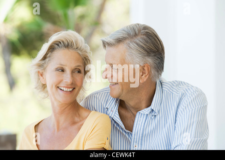 Mature couple smiling at each other outdoors Stock Photo