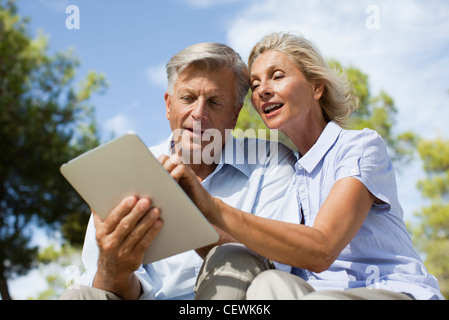 Couple using digital tablet outdoors Stock Photo