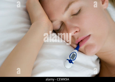 Young woman checking temperature with thermometer Stock Photo
