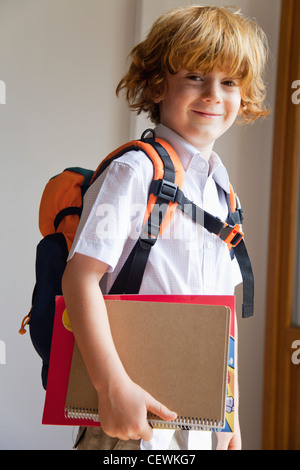 Boy prepared for school, carrying backpack and notebooks Stock Photo