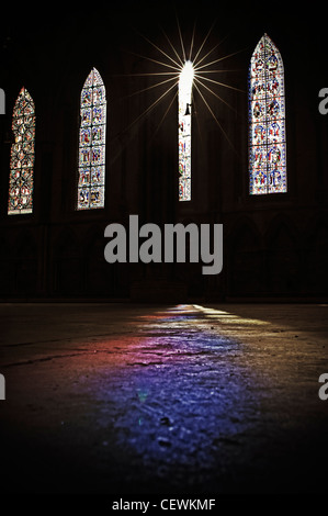 Stained glass windows in Lincoln Cathedral, casting colours onto the floor Stock Photo