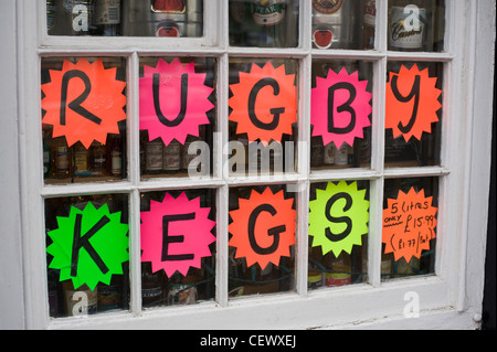 Rugby promotion cheap beer in kegs advert in off licence window Stock Photo