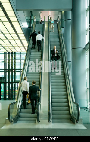 City employees on an escalator in Canary Wharf. Canary Wharf contains the UK's three tallest buildings; One Canada Square, the H Stock Photo