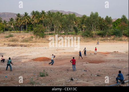 Indian boys playing cricket on a dry river bed in the rural Indian town of Puttaparthi, Andhra Pradesh, India Stock Photo