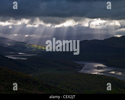 Rays of sunshine through storm clouds over the river Mawddach estuary. Stock Photo