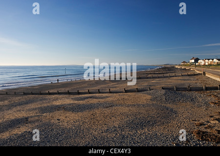 Walking the dog on a clear evening along Tywyn beach. Stock Photo