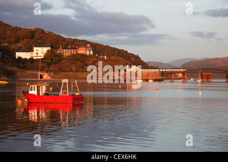 Barmouth harbour and railway bridge - a train is crossing the bridge. Stock Photo