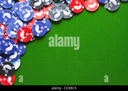 Colorful gambling chips on green felt background with copy space Stock Photo