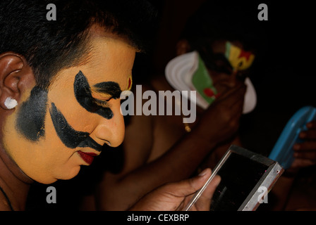 Kathakali Artist Applying Makeup for Kathakali Classical Dance Drama in Kerala, India.Makeup Room Scene from Temple Kathakali Stock Photo