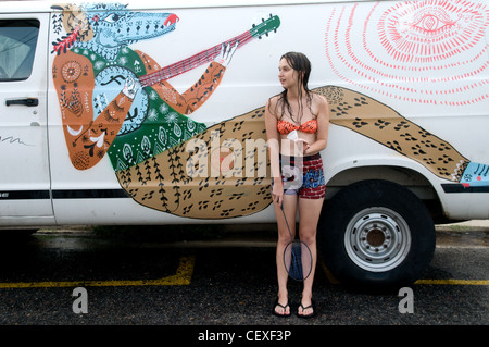 A portrait of an American female college student leaning on a white decorated van in the Marigny-Bywater neighbourhood of New Orleans, Louisiana, USA. Stock Photo