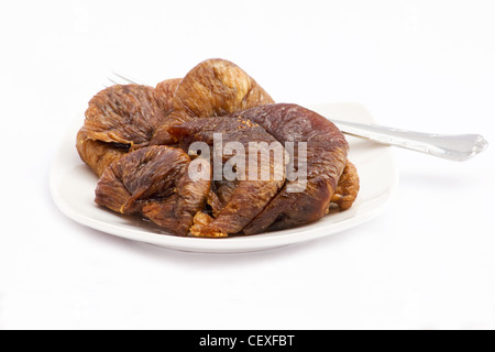 Dries figs in a white plate on white background Stock Photo