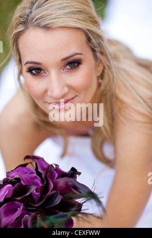Hispanic bride holding bouquet of flowers Stock Photo
