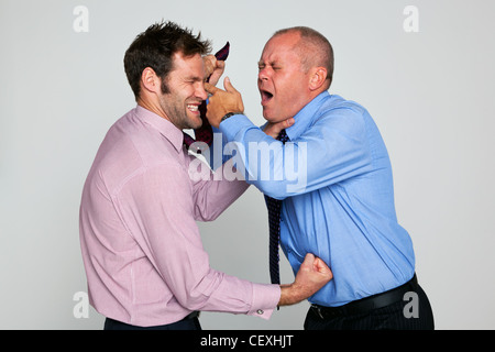 Photo of two businessmen fighting against a plain background Stock Photo