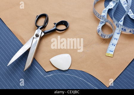 Still life photo of a suit pattern template with tape measure, chalk and scissors. Stock Photo