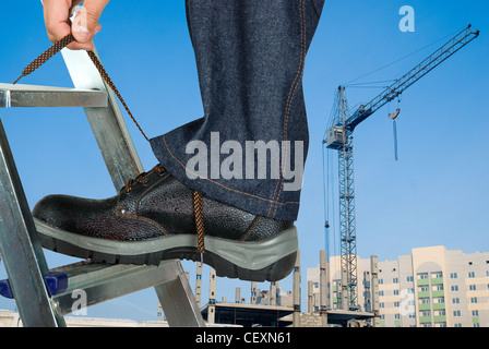 repairman lace his shoes on building background Stock Photo