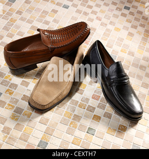 A still life shot of a three men's shoes on a mossiac floor Stock Photo