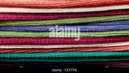 still life shot of a stack of layered colourful wool scarves Stock Photo