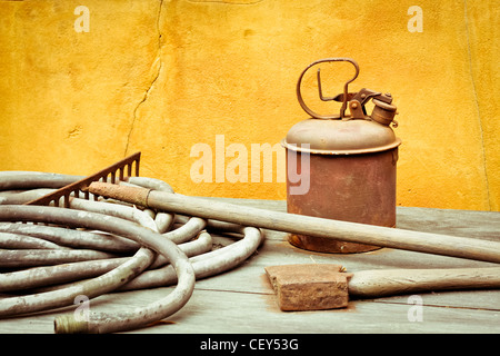 A selection of antique gardening tools on a wooden surface Stock Photo