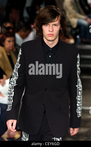 Commes Des Garcons Paris Menswear S S Male model wearing black suit white musical notes print details Audience in the Stock Photo