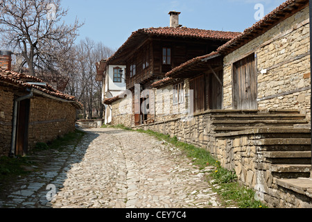 Stone paved street in spring season Zheravna village, Bulgaria with beautiful wooden houses Stock Photo
