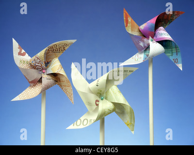 Three major European currency banknotes - Euro, Swiss Franc and British Pound cut into toy windmills shot on blue background Stock Photo