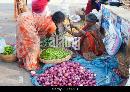 Indian woman buying green chili vegetables from a street market in Puttaparthi, Andhra Pradesh, India Stock Photo
