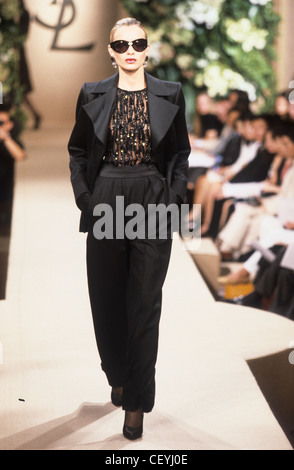 Yves Saint Laurent Spring Summer Female wearing white shirt, loose fit  beige trousers, and brown turban Stock Photo - Alamy