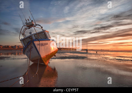 A boat moored at sunrise during low tide at 'Thorpe Bay' Essex Stock Photo