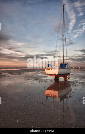 A Yacht beached at low tide at 'Thorpe Bay' Essex Stock Photo