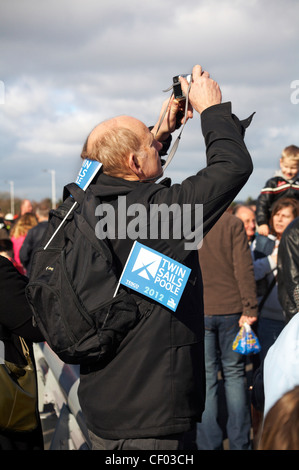 Man taking photos as the crowds pass by at the opening of the new twin sails lifting bridge crossing Poole Harbour in Poole, Dorset UK on 25 Feb 2012 Stock Photo