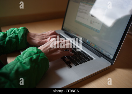 Close up of forty year old woman typing on her lap top keyboard, computer work. Stock Photo