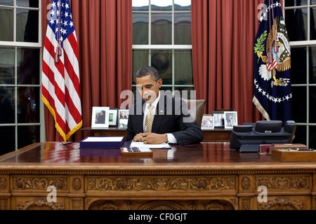 President Barack Obama signs into law the Middle Class Tax Relief and Job Creation Act of 2012 in the Oval Office of the White House February 22, 2012 in Washington, DC. Stock Photo