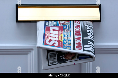 The first edition of the new Sun On Sunday newspaper is seen in the letterbox of a buyer in Wiltshire UK. Stock Photo