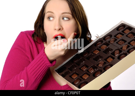 Woman indulging in a large box of chocolate candy. Stock Photo