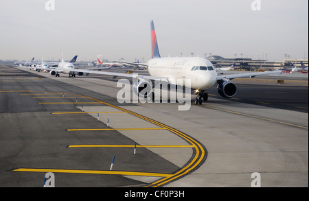 Commercial airliners lined up on runway, awaiting take-off,  at Newark Liberty International Airport, Newark, NJ Stock Photo