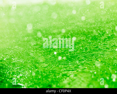 Lime green splashing water closeup abstract background texture Stock Photo