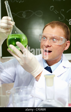 Happy male scientist looking at a new substance obtained in laboratory Stock Photo