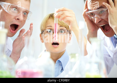 Three shocked scientists looking at the obtained substance expressing intense emotions Stock Photo