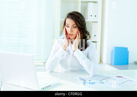Shocked business lady looking at the screen of laptop Stock Photo