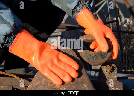 Closeup of worker man at orange gloves Stock Photo