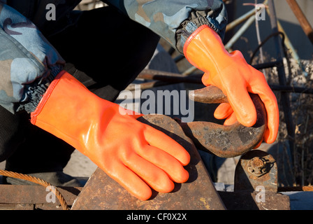 Closeup of worker man at orange gloves Stock Photo