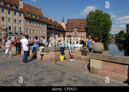 a group of students bathing in the hot afternoon sun on Museum bridge in Nuremberg, Germany Stock Photo