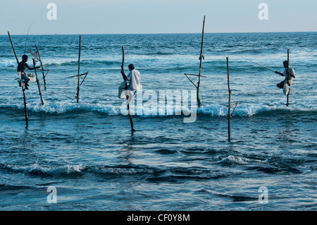 the stilt fishermen of southern Sri Lanka perched on their poles above the Indian Ocean Stock Photo
