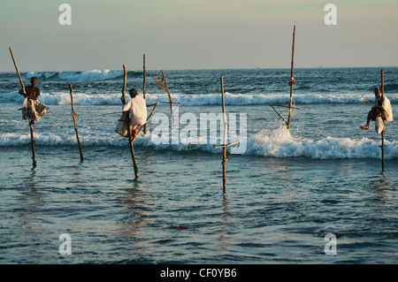 the stilt fishermen of southern Sri Lanka perched on their poles above the Indian Ocean Stock Photo