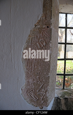 Ancient graffiti scratched on the wall of the entrance porch of St. Mary's church Apuldram. Stock Photo